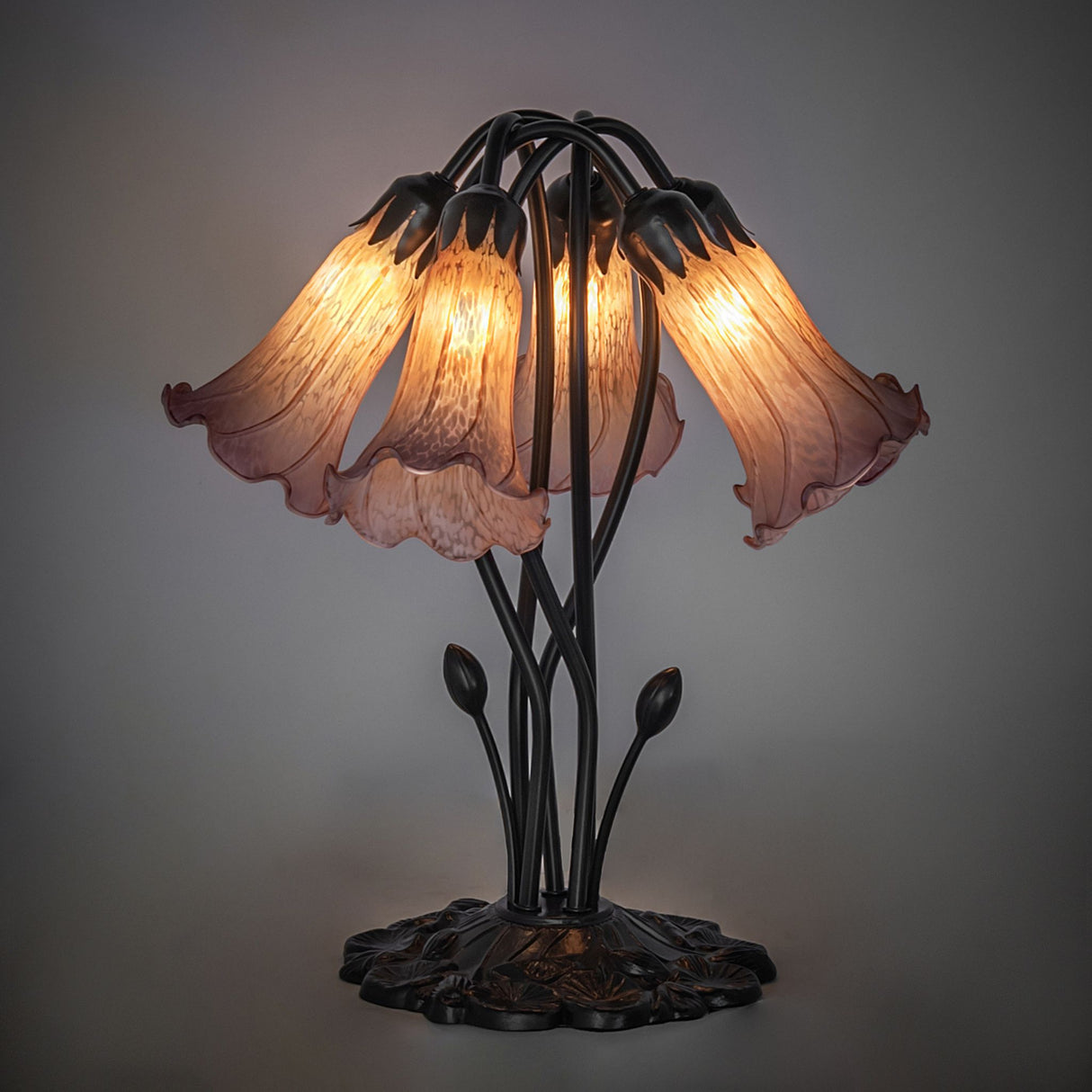 Illuminated amber and purple pond lily table lamp with artistic glass shades.