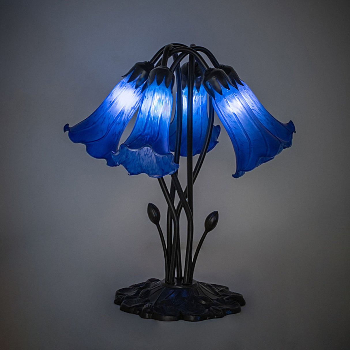 Illuminated blue pond lily table lamp with artistic glass shades.
