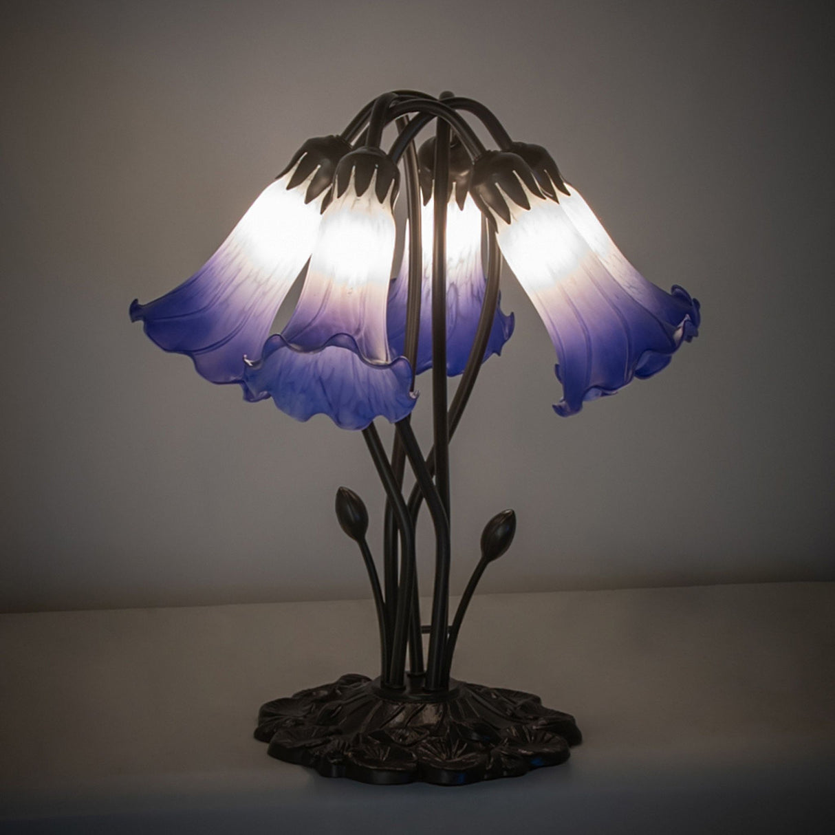Illuminated blue and white pond lily table lamp with artistic glass shades.