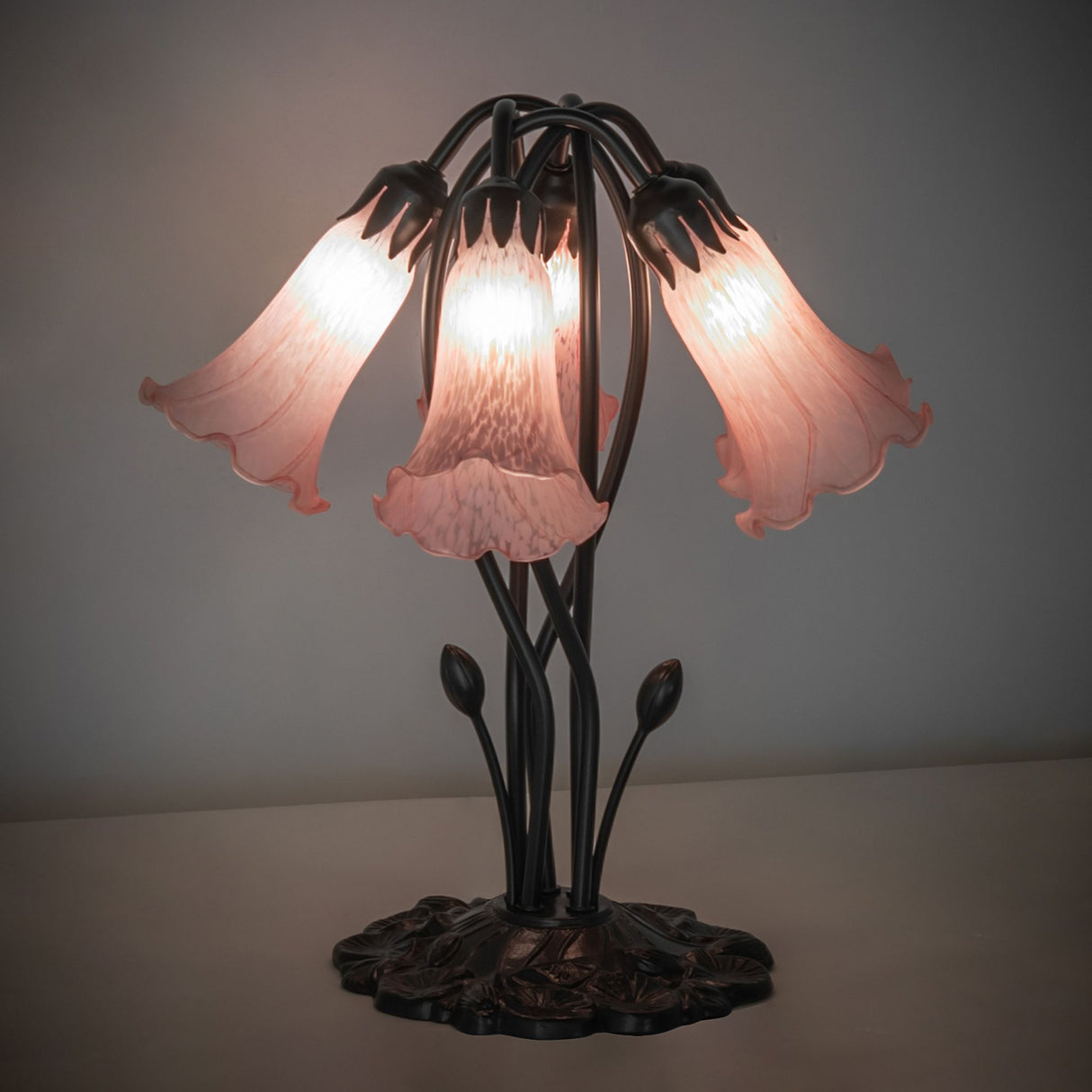 Illuminated pink pond lily table lamp with artistic glass shades.