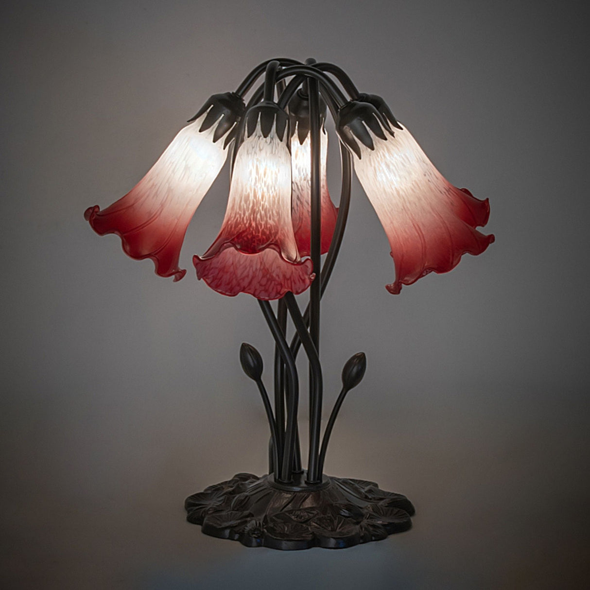 Illuminated Pink and white pond lily table lamp with artistic glass shades.
