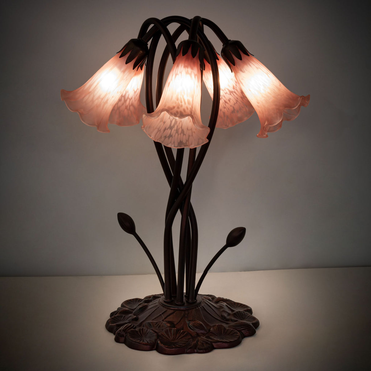 Illuminated view of pink Tiffany lamp in dim lighting.