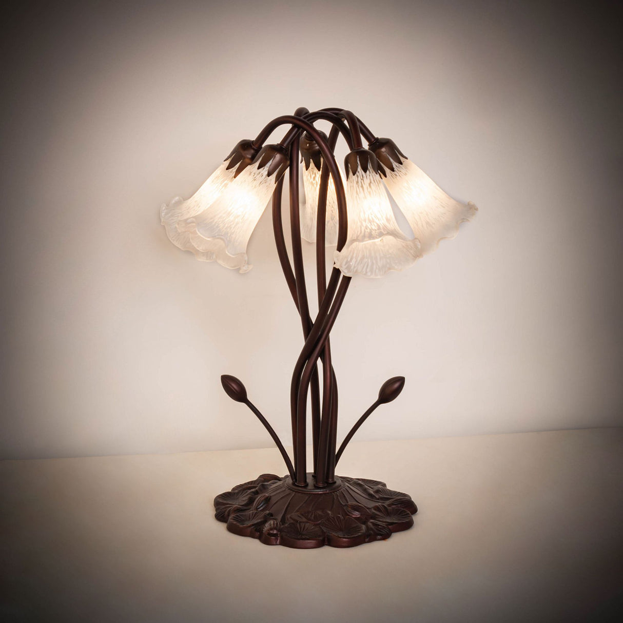 Warmly illuminated 17" white pond lily lamp in a dimly lit setting.