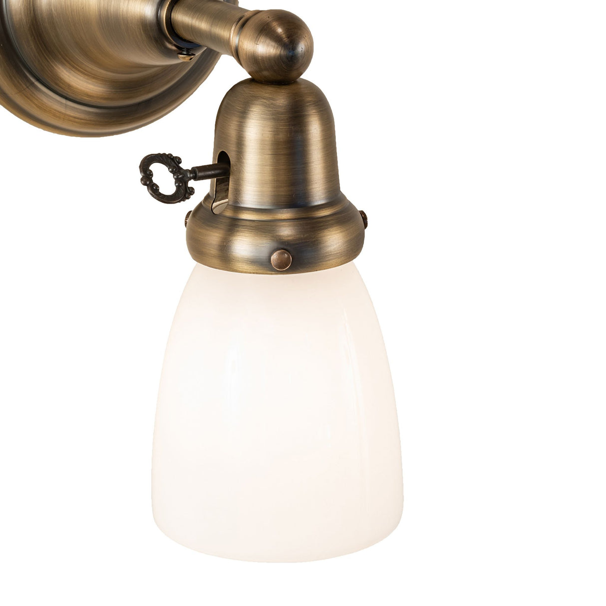 Close-up of the opal glass shade and brass details of the wall sconce.
