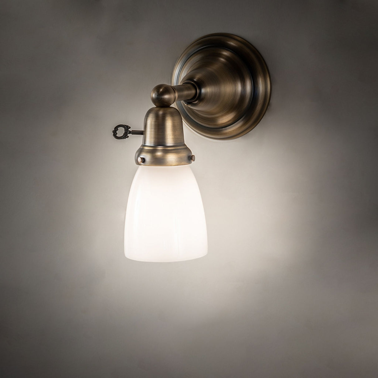 Illuminated Revival Goblet Wall Sconce with antique brass finish.