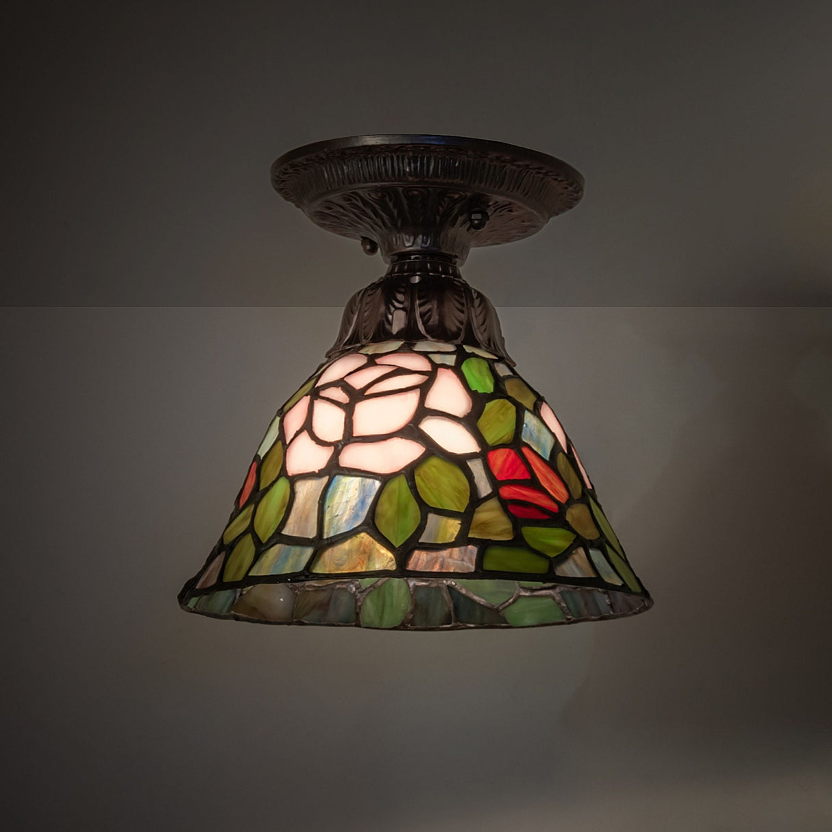 Illuminated Tiffany rosebush flushmount with intricate floral glass pattern.