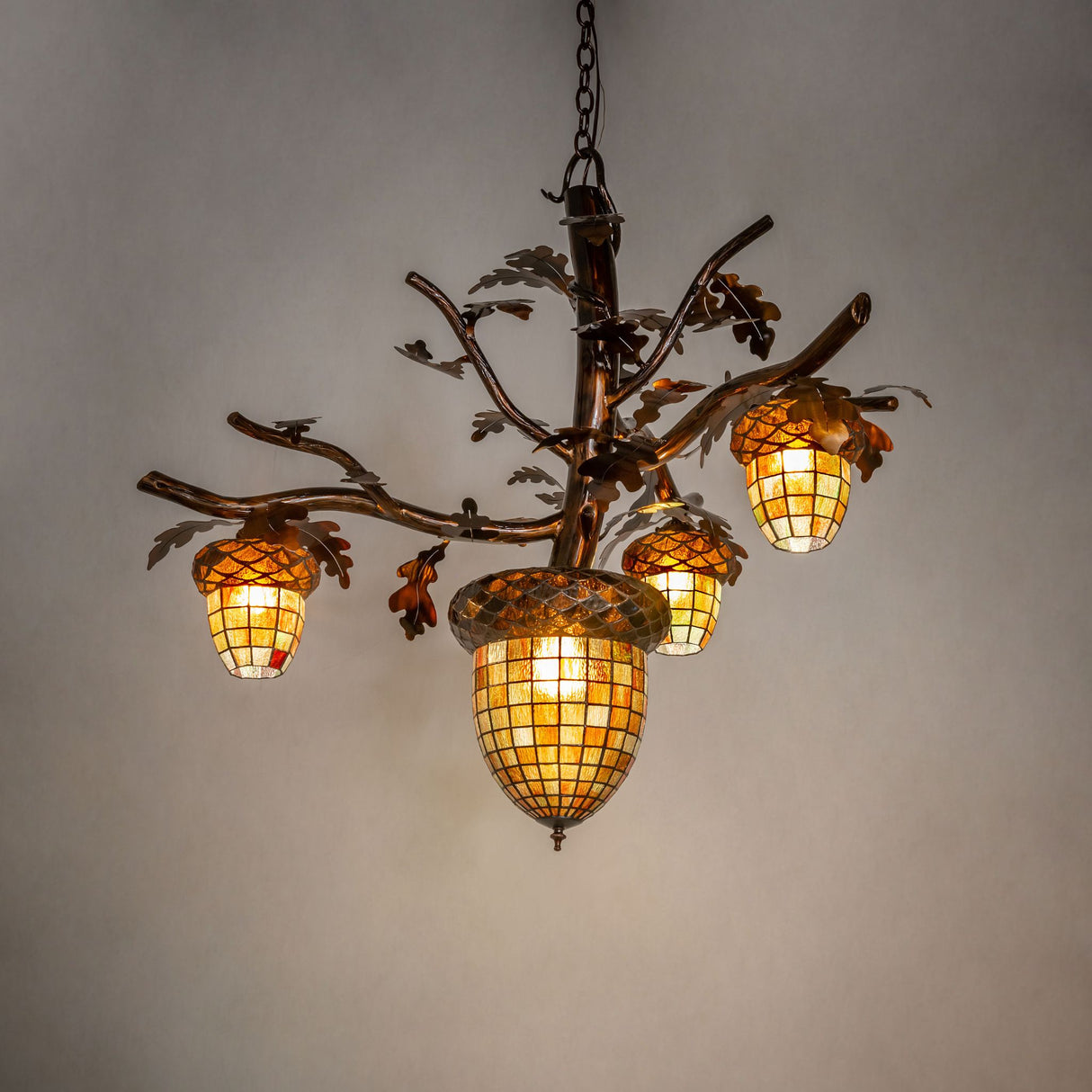 Acorn 4 light chandelier glowing in an ambient room setting.