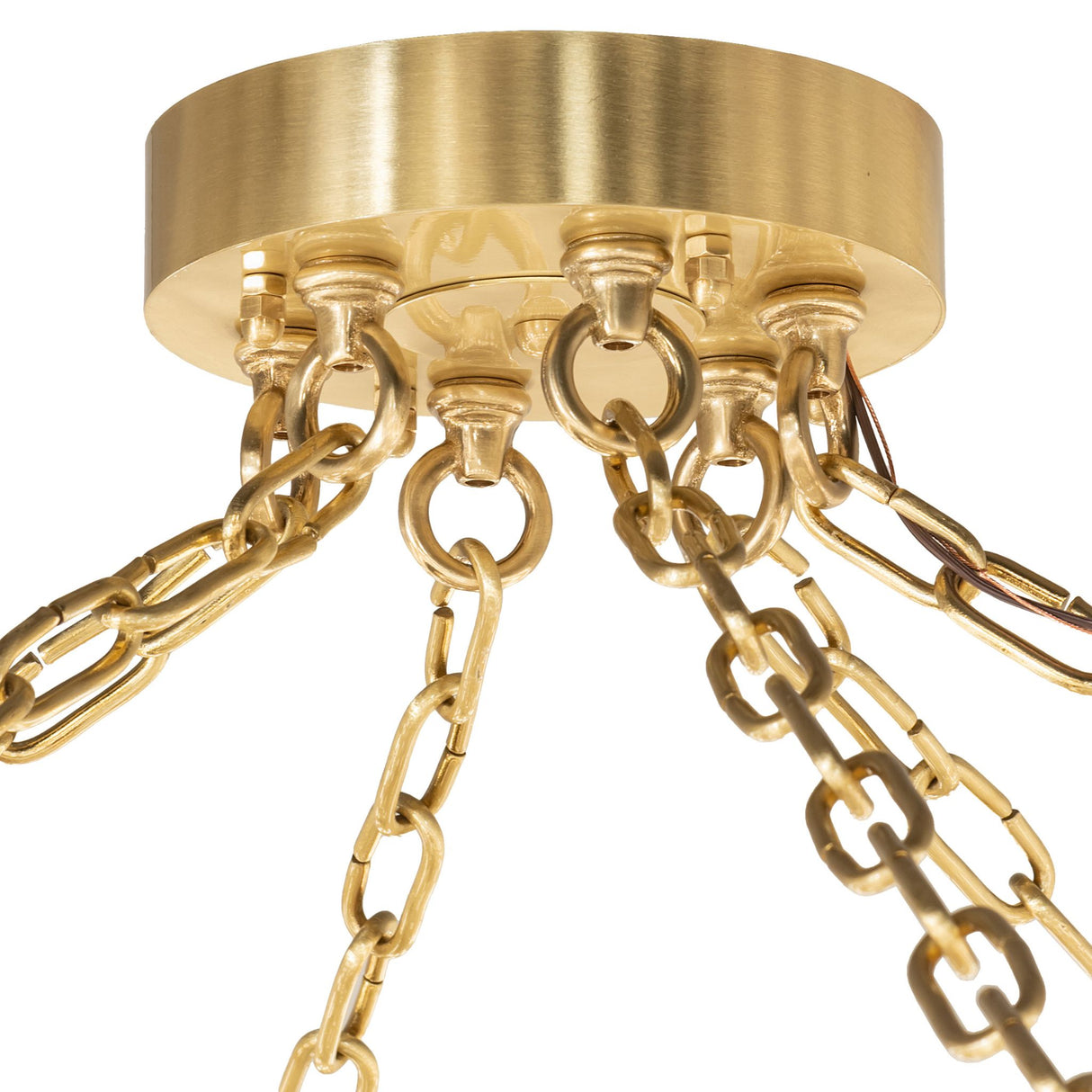 Close-up of brushed brass chandelier canopy with hanging chain links.