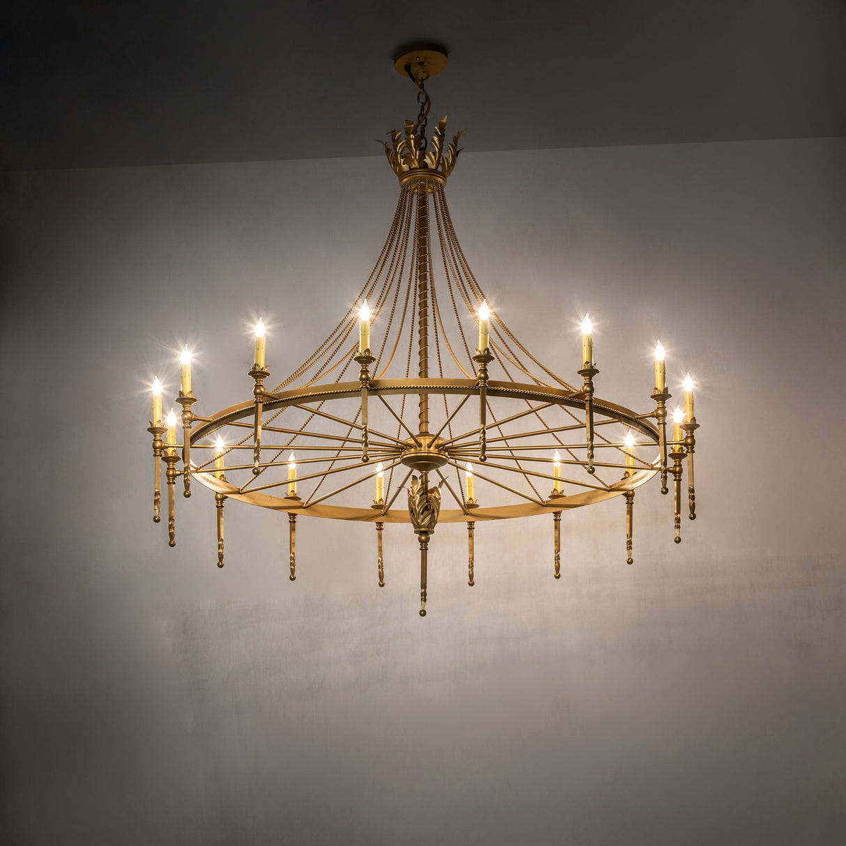 Gold Amaury chandelier illuminated in an interior setting, showcasing soft ambient light and elegant scale.