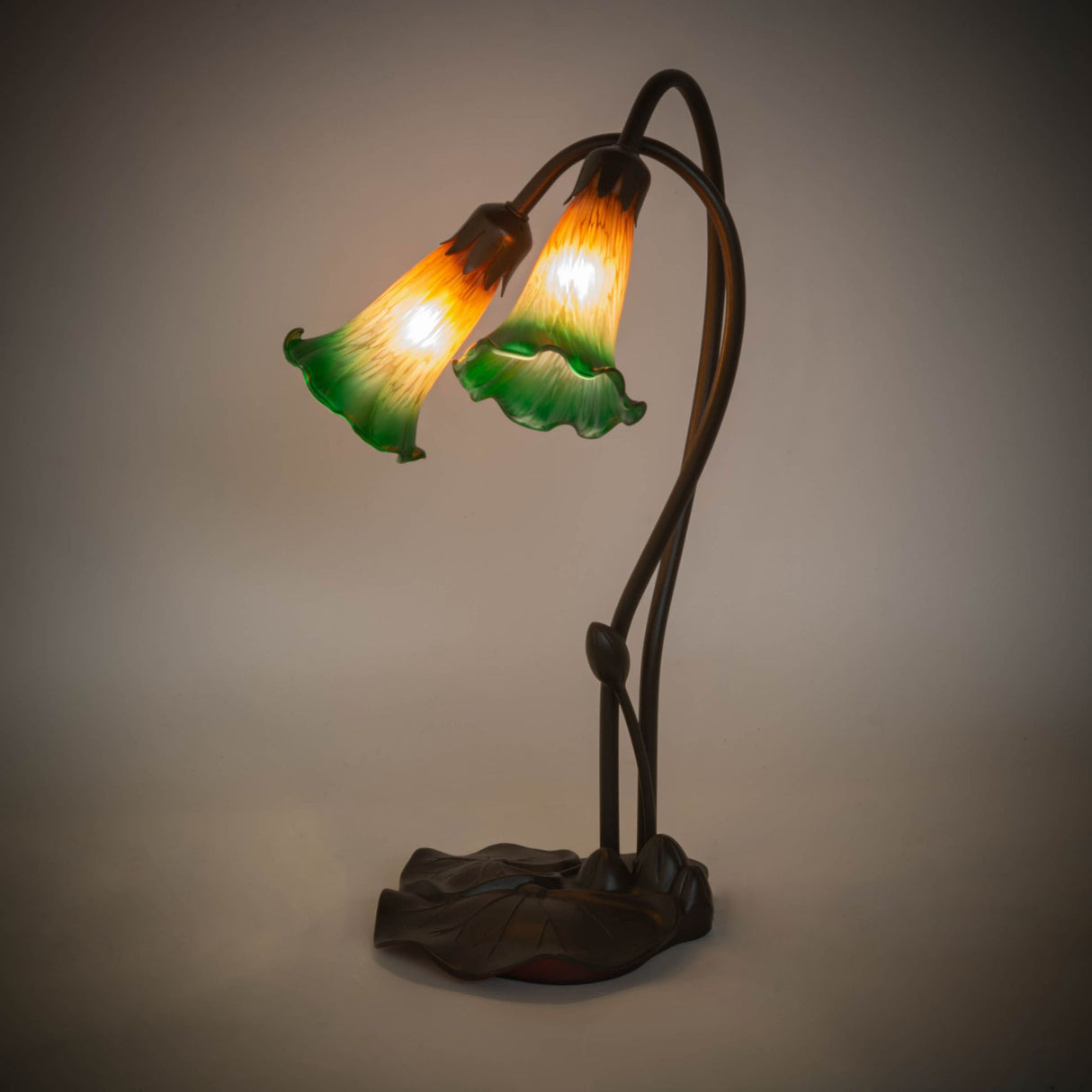 Illuminated view of the Amber/Green Pond Lily accent lamp glowing with warm tones.