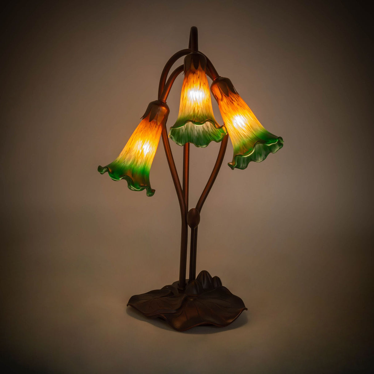 illuminated view of tiffany pond lily accent lamp showcasing warm amber-green glow.
