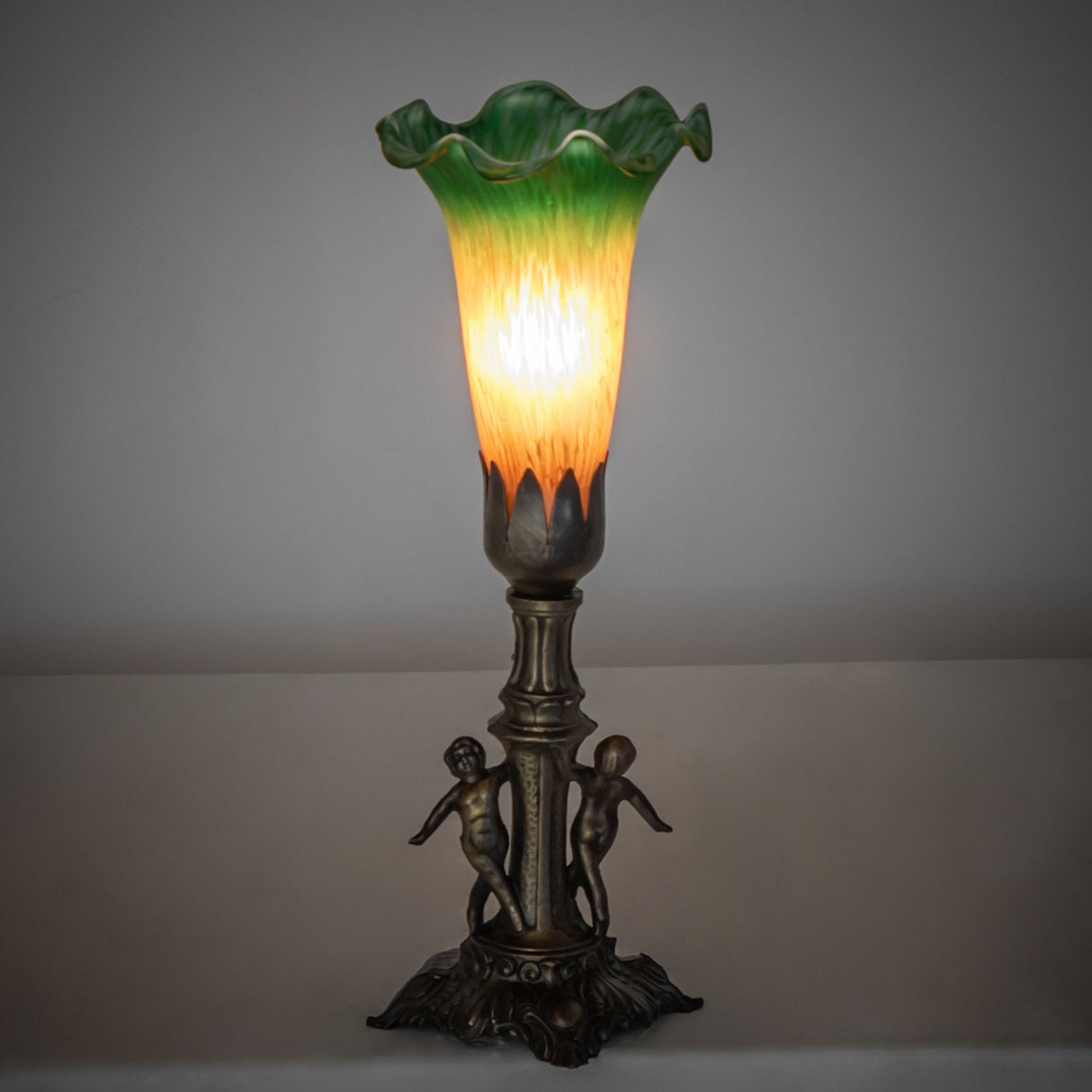 Ambient view of the Pond Lily Maidens Mini Lamp, casting a warm glow with its exquisite hand-blown glass shade.