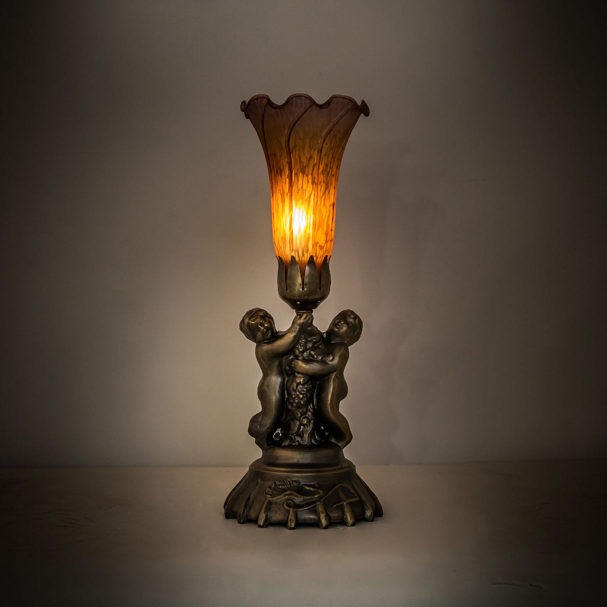 Amber and purple pond lily cherub lamp in a dim ambient setting.