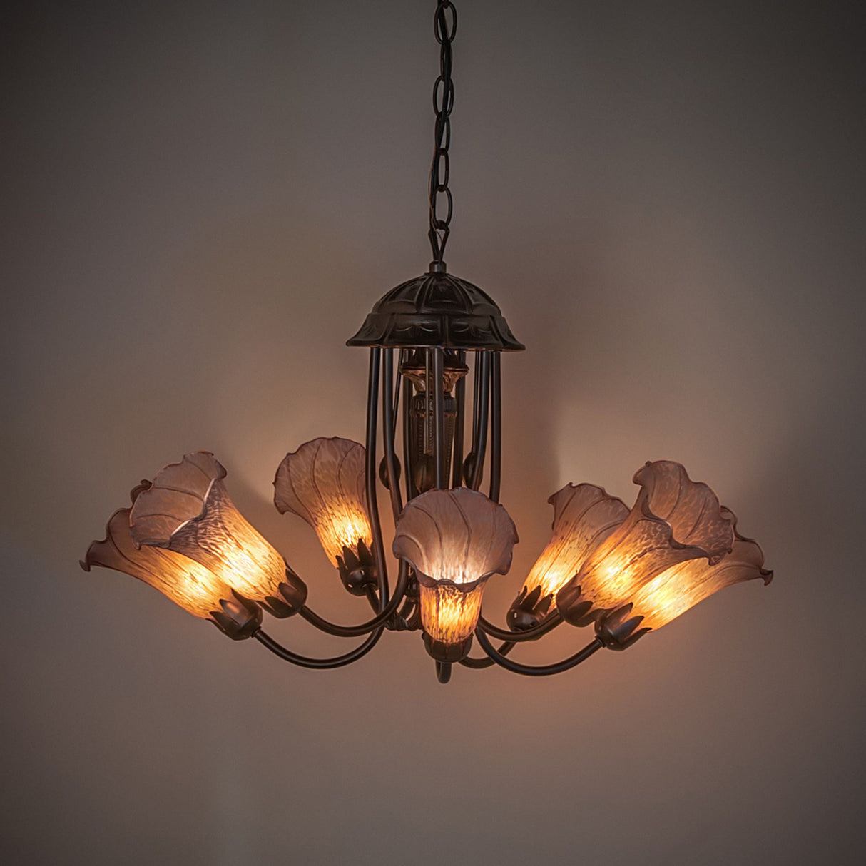 Illuminated chandelier showcasing the radiant amber and purple glass tones.