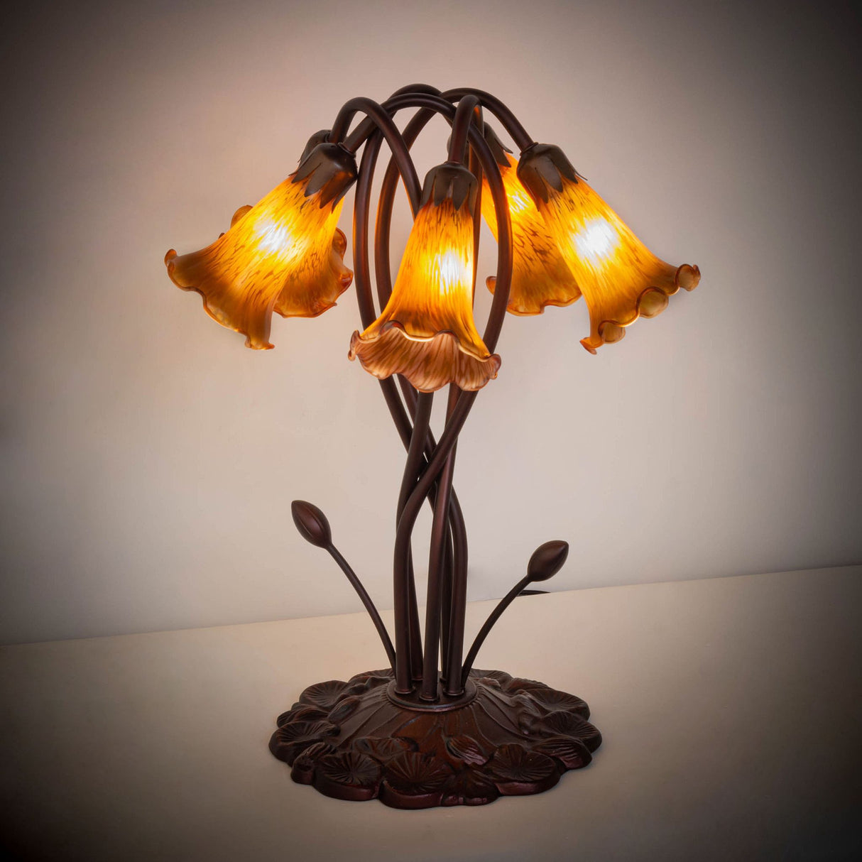 Amber Tiffany lamp glowing warmly in a softly lit setting.