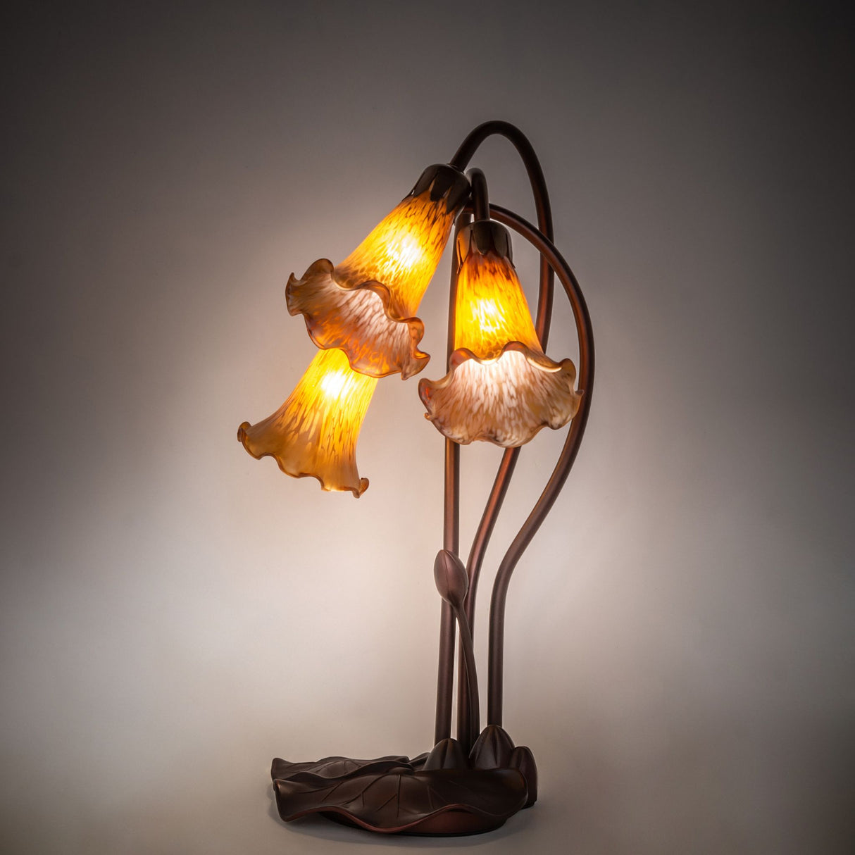 illuminated view of amber tiffany pond lily accent lamp showcasing warm, rich amber glow.