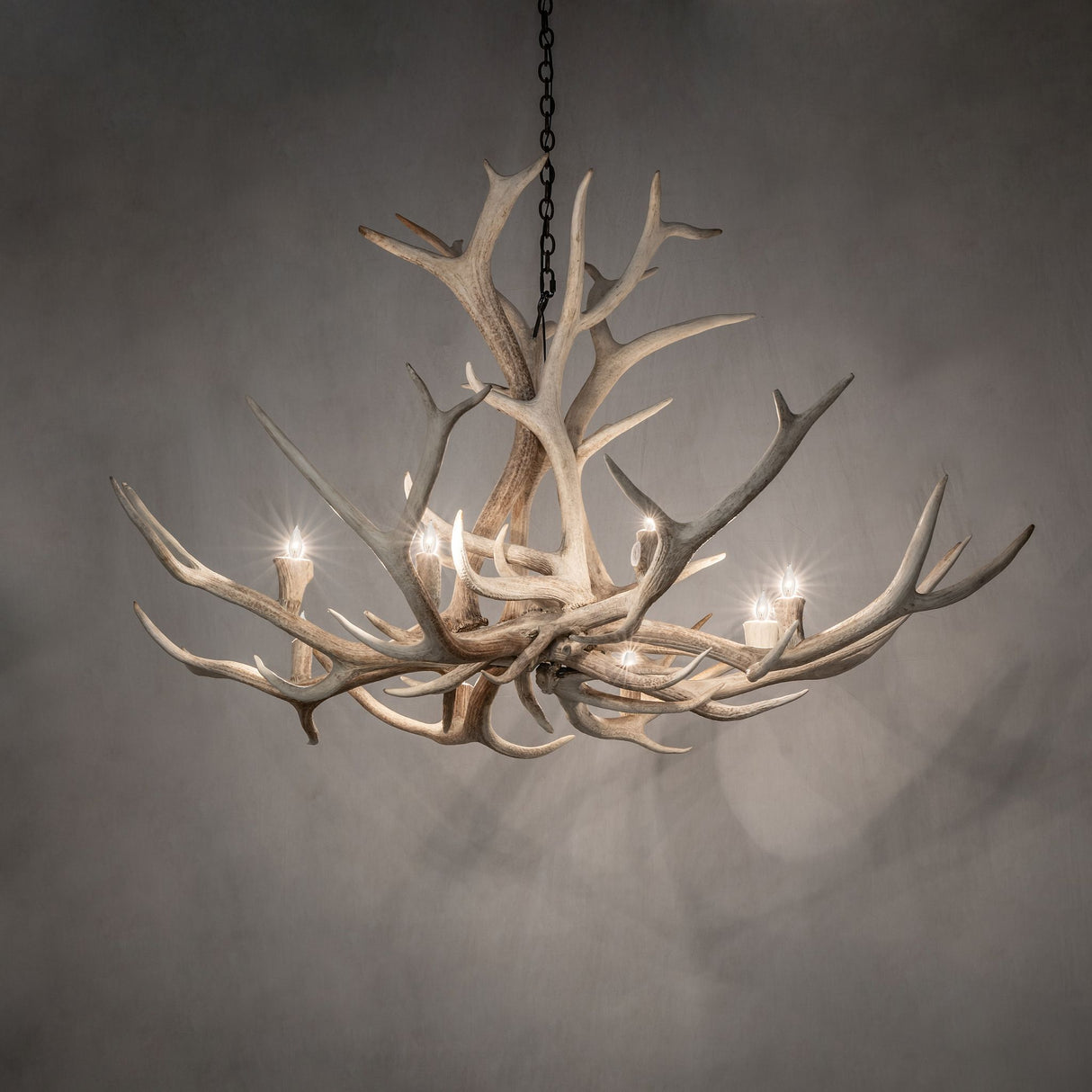 Elk antler chandelier softly illuminated in an ambient room.