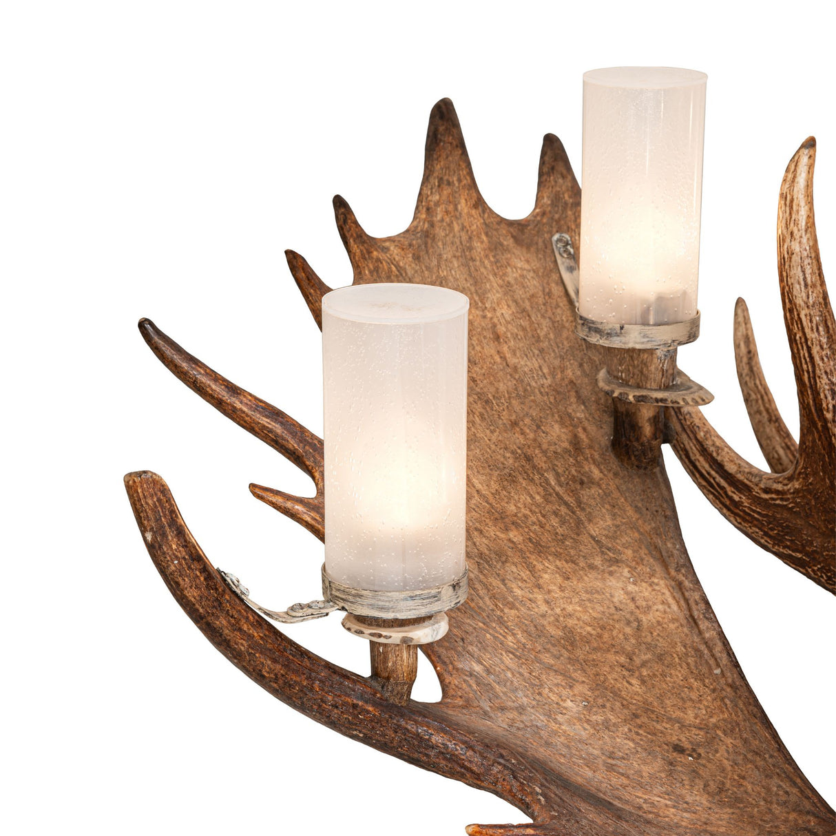 Close-up detail of antler surface with seeded glass cylinder and antique brass hardware.