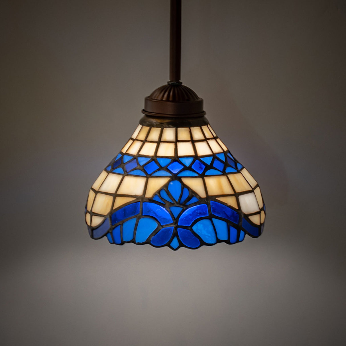 Illuminated Baroque mini pendant showcasing vibrant blue and beige glass.