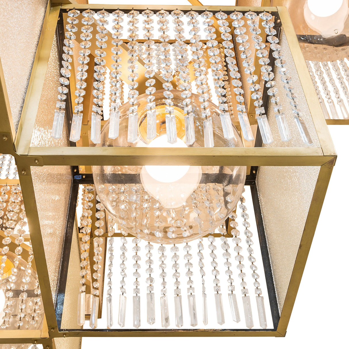 Detail view of crystal bead drape and brushed brass cube structure.