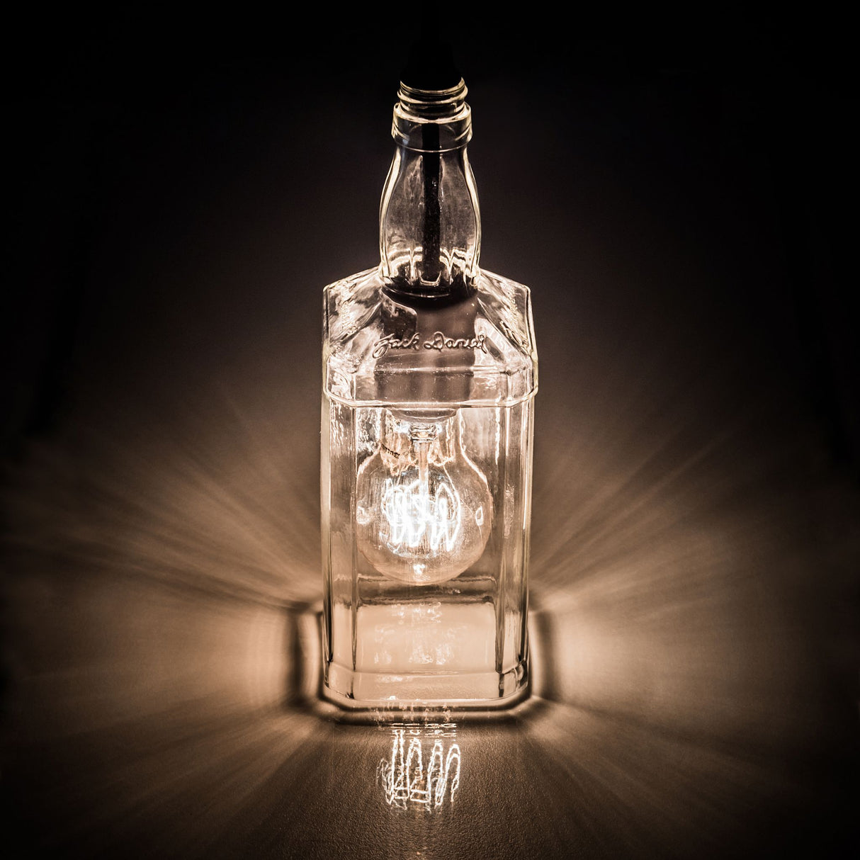 Illuminated bourbon bottle pendant casting a warm glow.