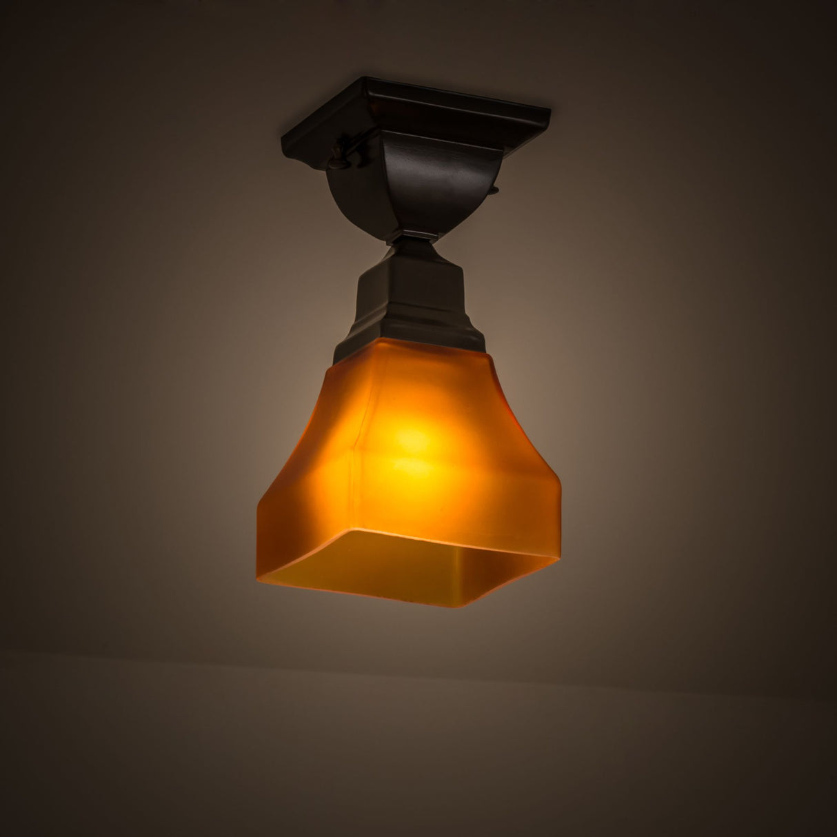 Amber glass flushmount illuminating with a soft ambient glow.