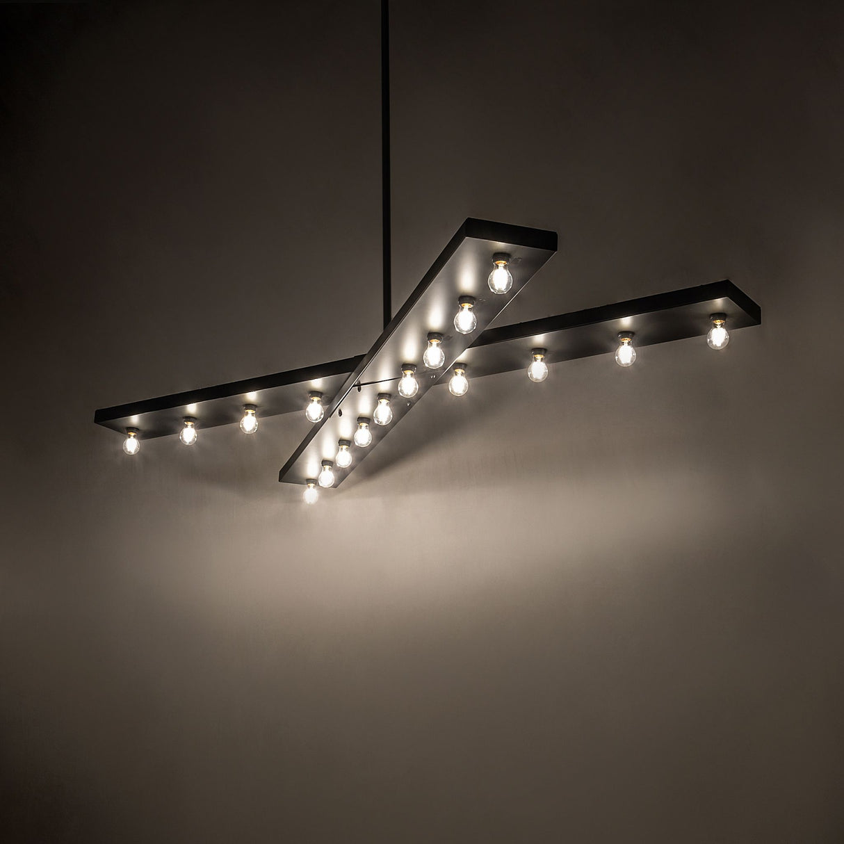 Caldero 17 light oblong chandelier creating warm ambient glow over modern interior.