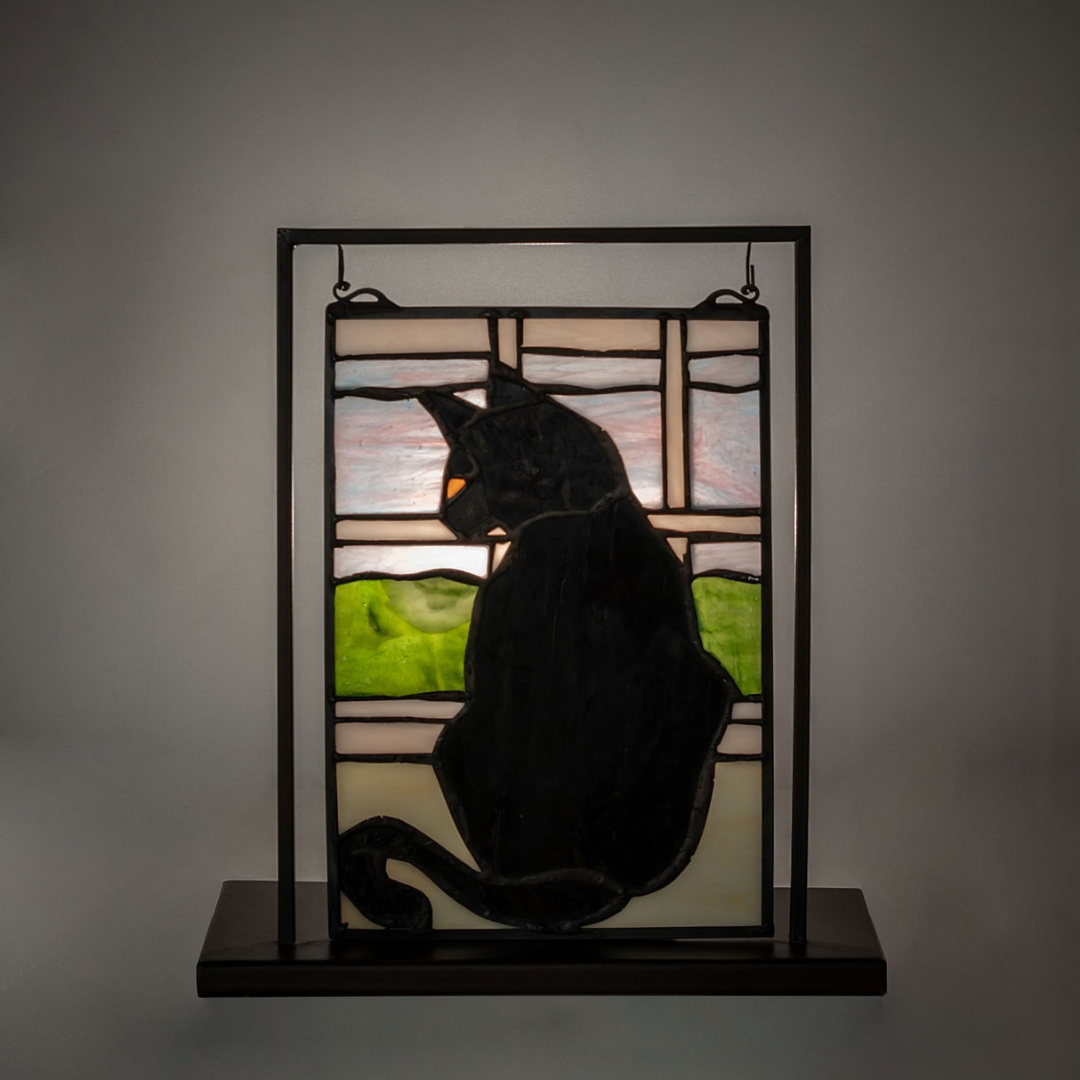 illuminated cat in window lighted mini tabletop window highlighting vibrant stained glass colors with a black cat design.