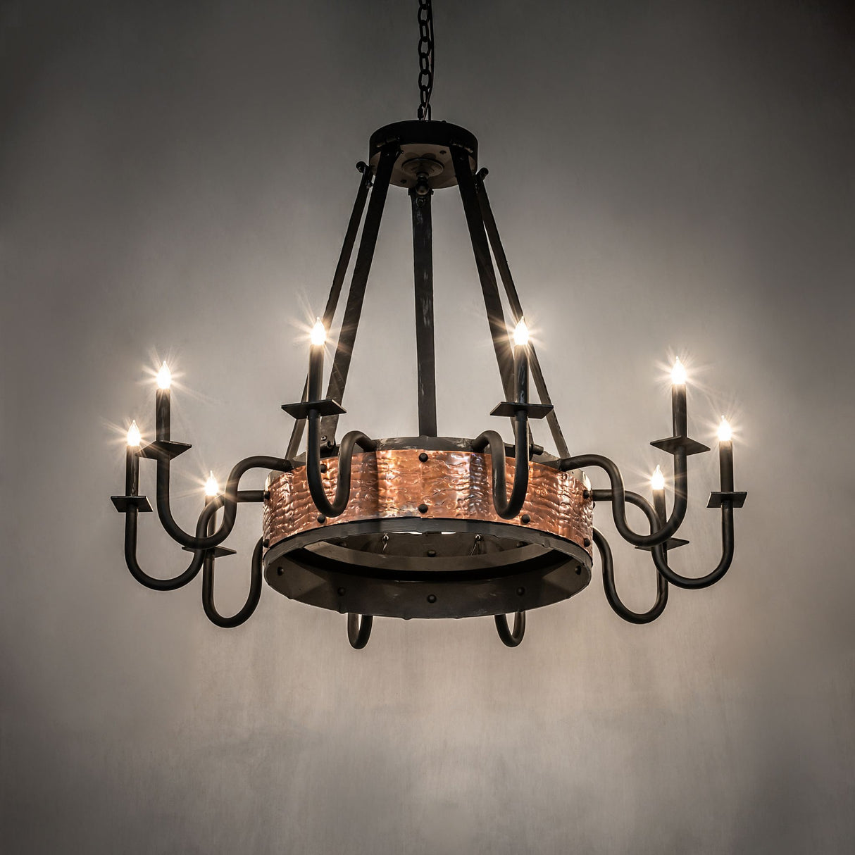 Ambient view of Costello chandelier showing warm glow and rustic copper detailing.