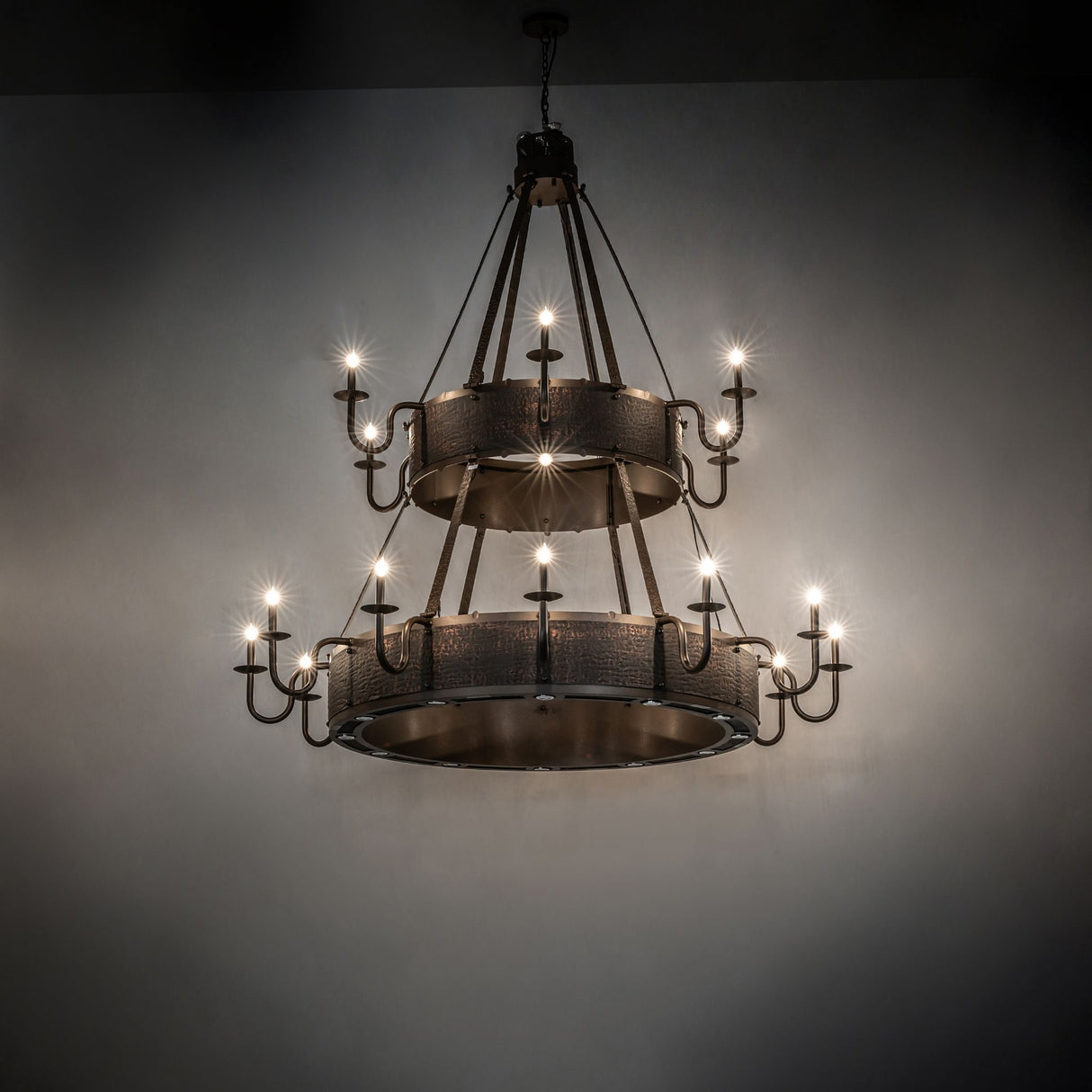 Dark room view of the Costello chandelier illuminated by candle-style lights.
