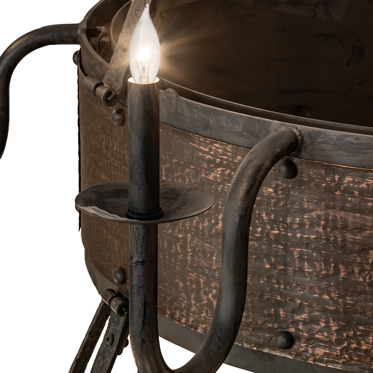 Close-up of single candlelight arm with rustic metal texture.