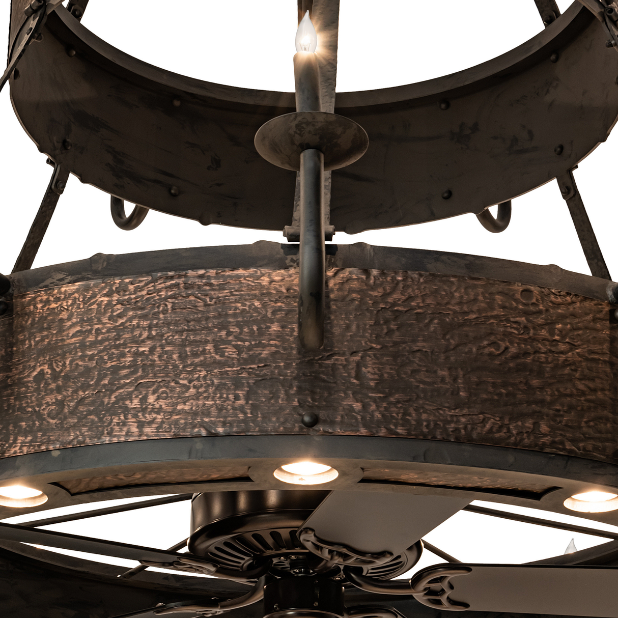 Close-up showing fan blades beneath glowing candlelight tiers.