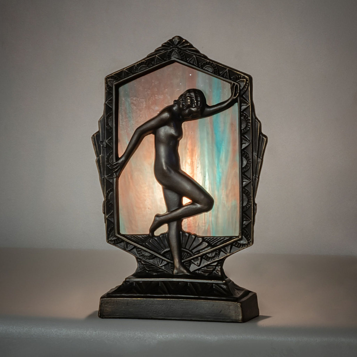 Art Deco accent lamp featuring a posing lady with a purple art glass backdrop.