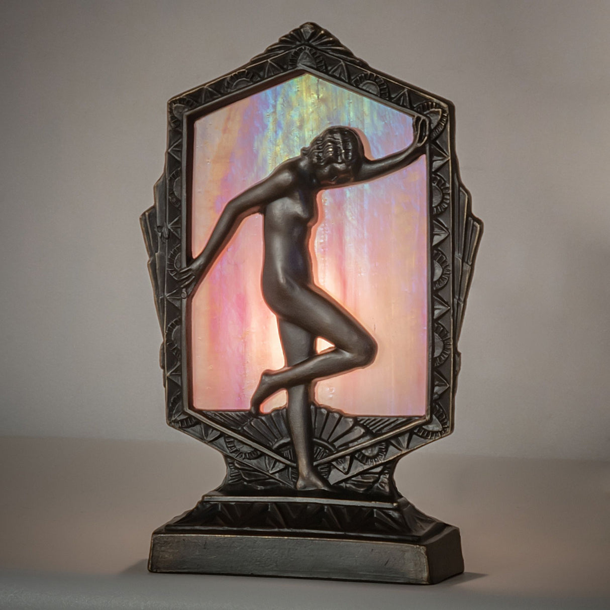 Ambient view of the Deco Posing Lady Accent Lamp, glowing with pink iridescent glass.