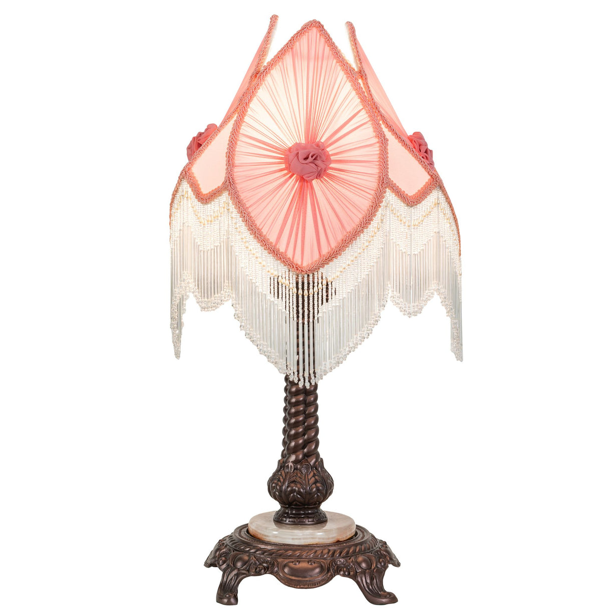 Elegant pink lampshade with layered fringe on decorative lamp base.