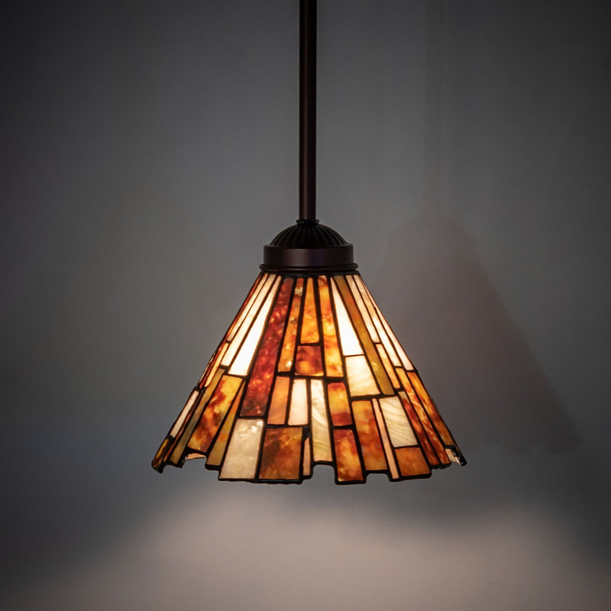 Delta Jadestone Mini Pendant illuminated, highlighting its warm glow.