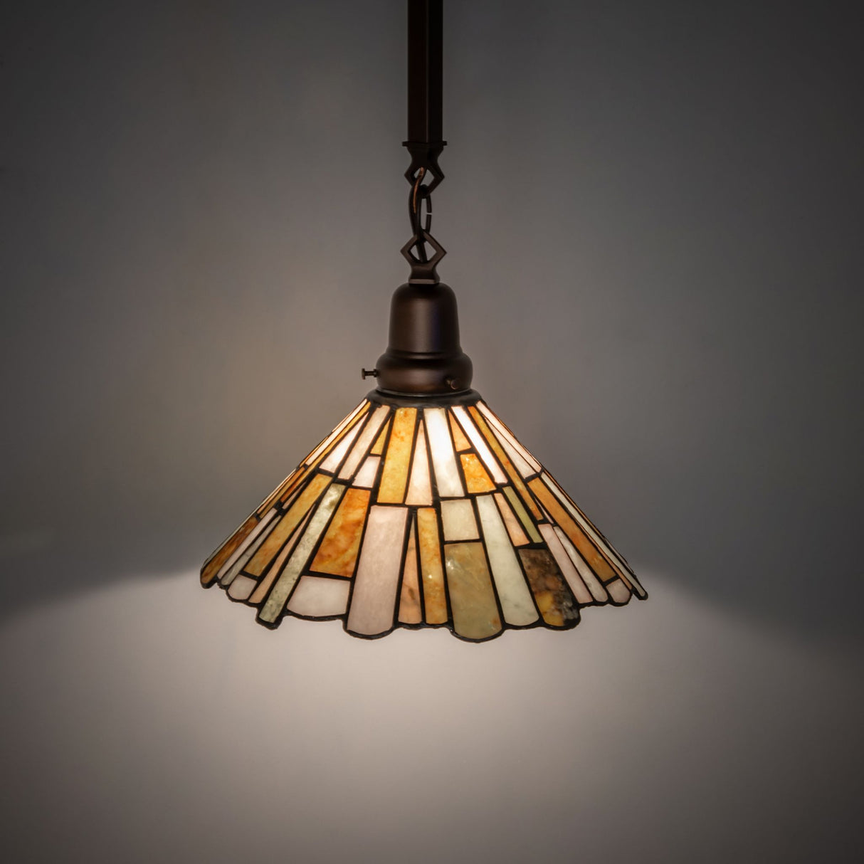 Illuminated Delta Jadestone Pendant showcasing vibrant earthy tones.