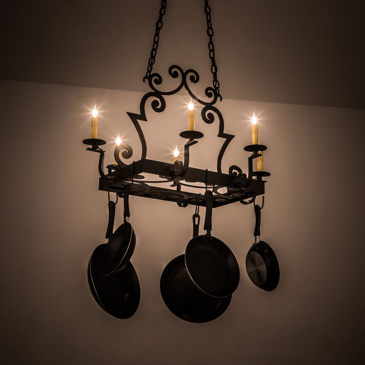 Elara 6 Light Pot Rack chandelier glowing warmly in dark setting.