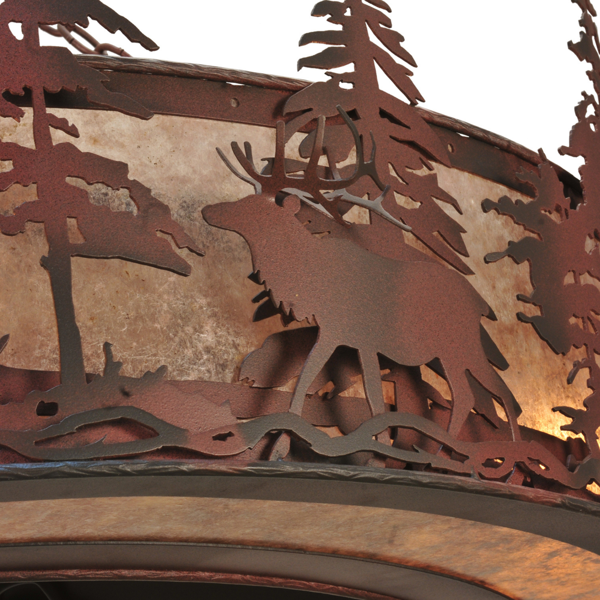 Closeup of elk figure and handcrafted pine cutouts in metal frame.