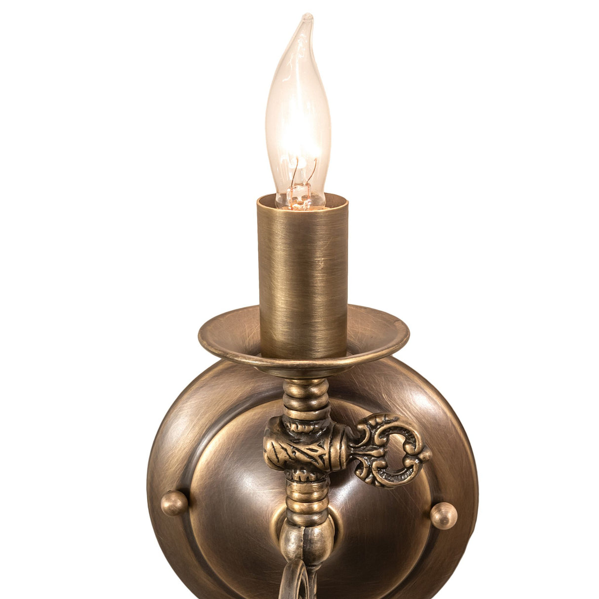 Close-up view of antique brass wall sconce with flame bulb.