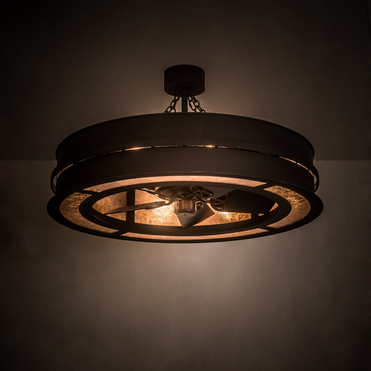 Illuminated Golden Forge Chandel-Air glowing warmly in a dim room with rustic metal frame.