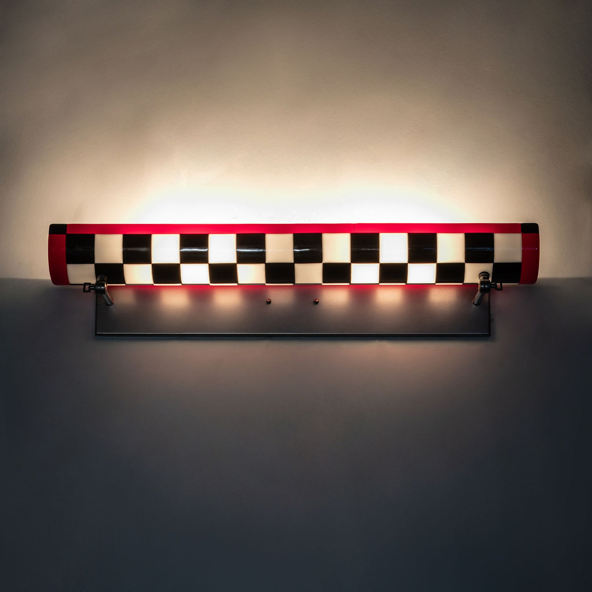 Fully illuminated Grand Prix Picture Light Wall Sconce showcasing its bold checkered design.