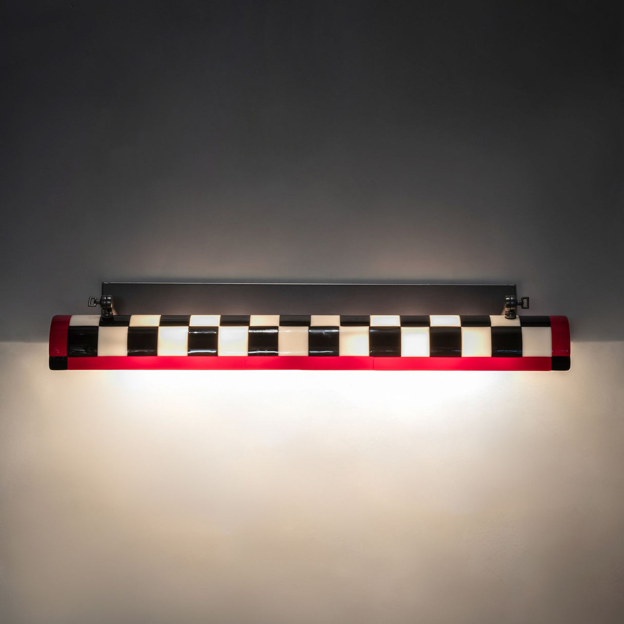 Illuminated Grand Prix Picture Light Wall Sconce casting a warm glow on the wall.
