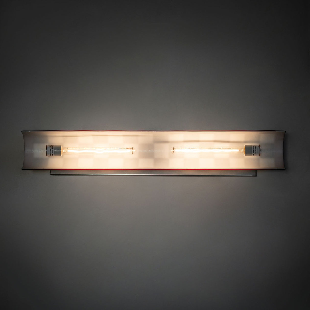 The Grand Prix Picture Light Wall Sconce casting a soft glow on the surrounding wall.