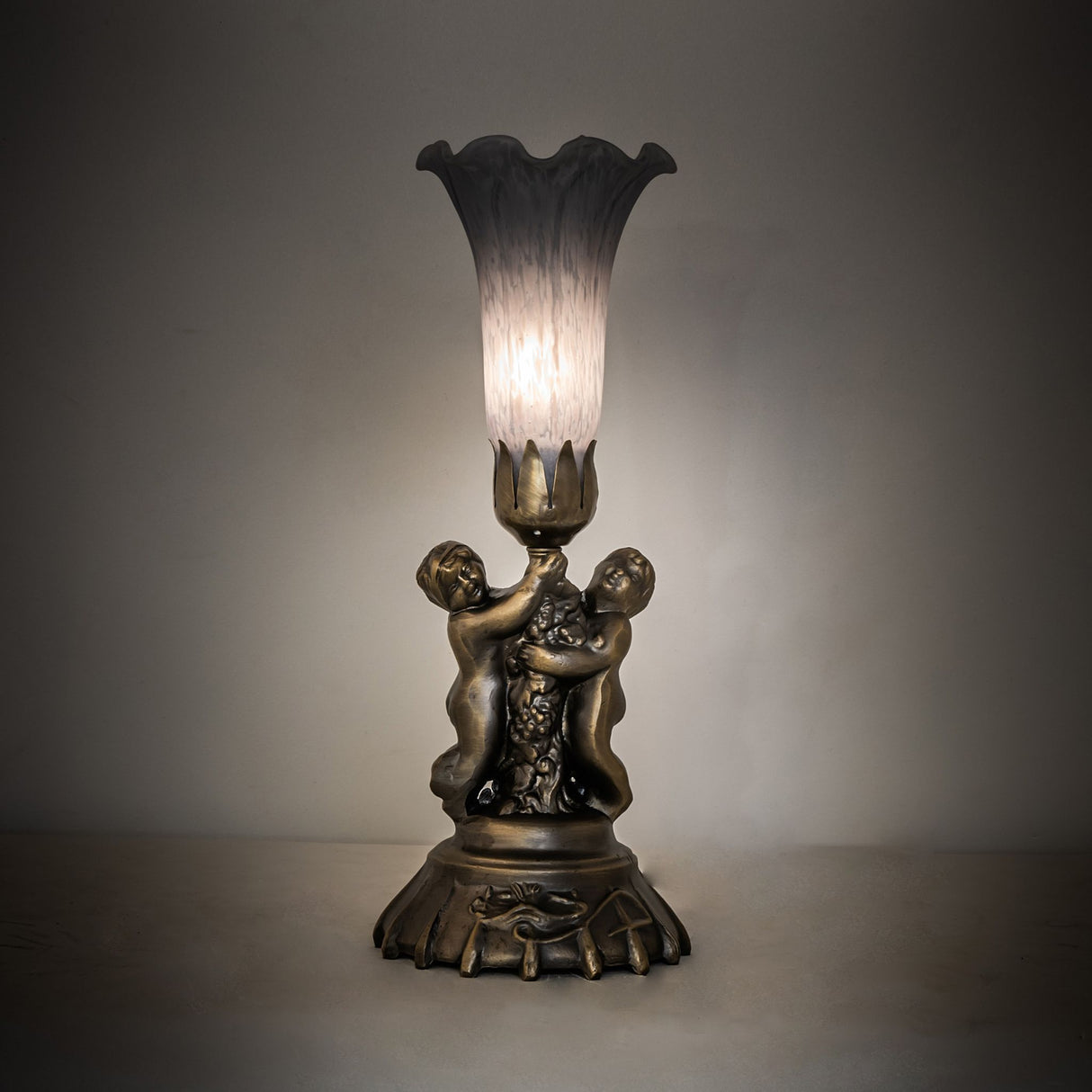 Gray pond lily cherub lamp illuminated in ambient room setting.
