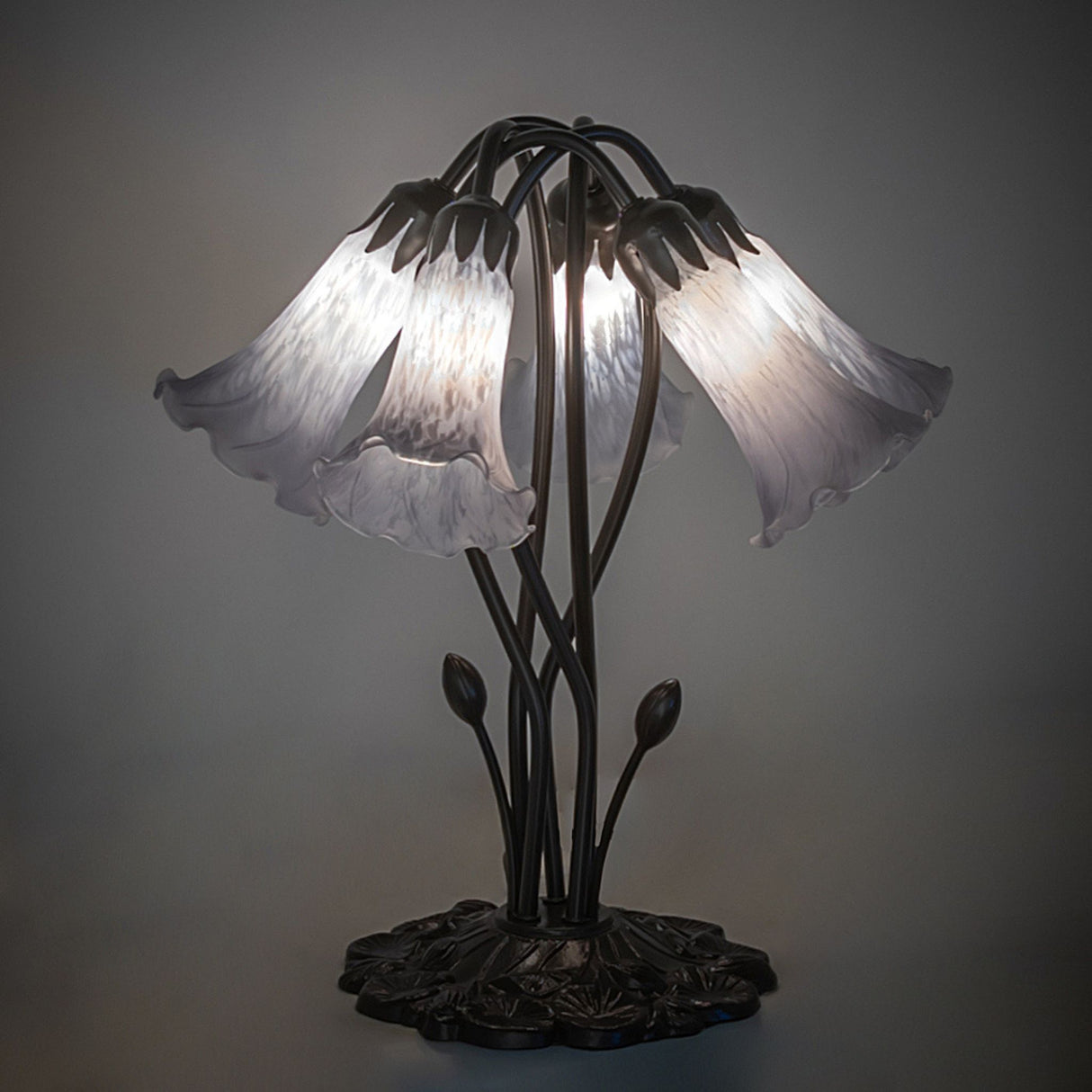 Illuminated gray pond lily table lamp with artistic glass shades.