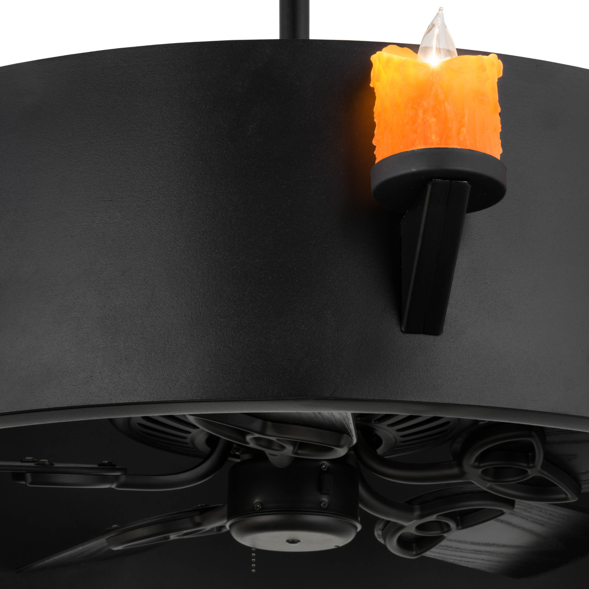 Closeup showing illuminated amber candle and fan assembly.