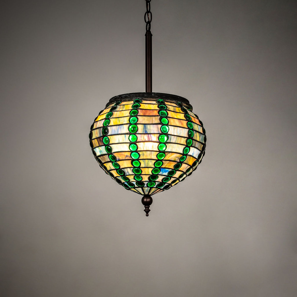Illuminated view of the Jeweled Beehive Pendant with vibrant colored glass and a warm glow.