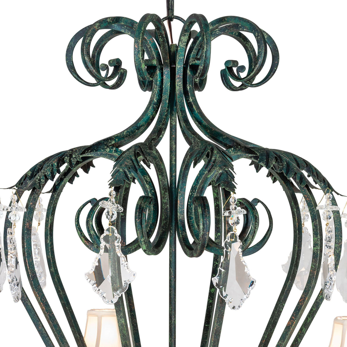 Close up of upper scrollwork and crystal pendalogues detail on chandelier.