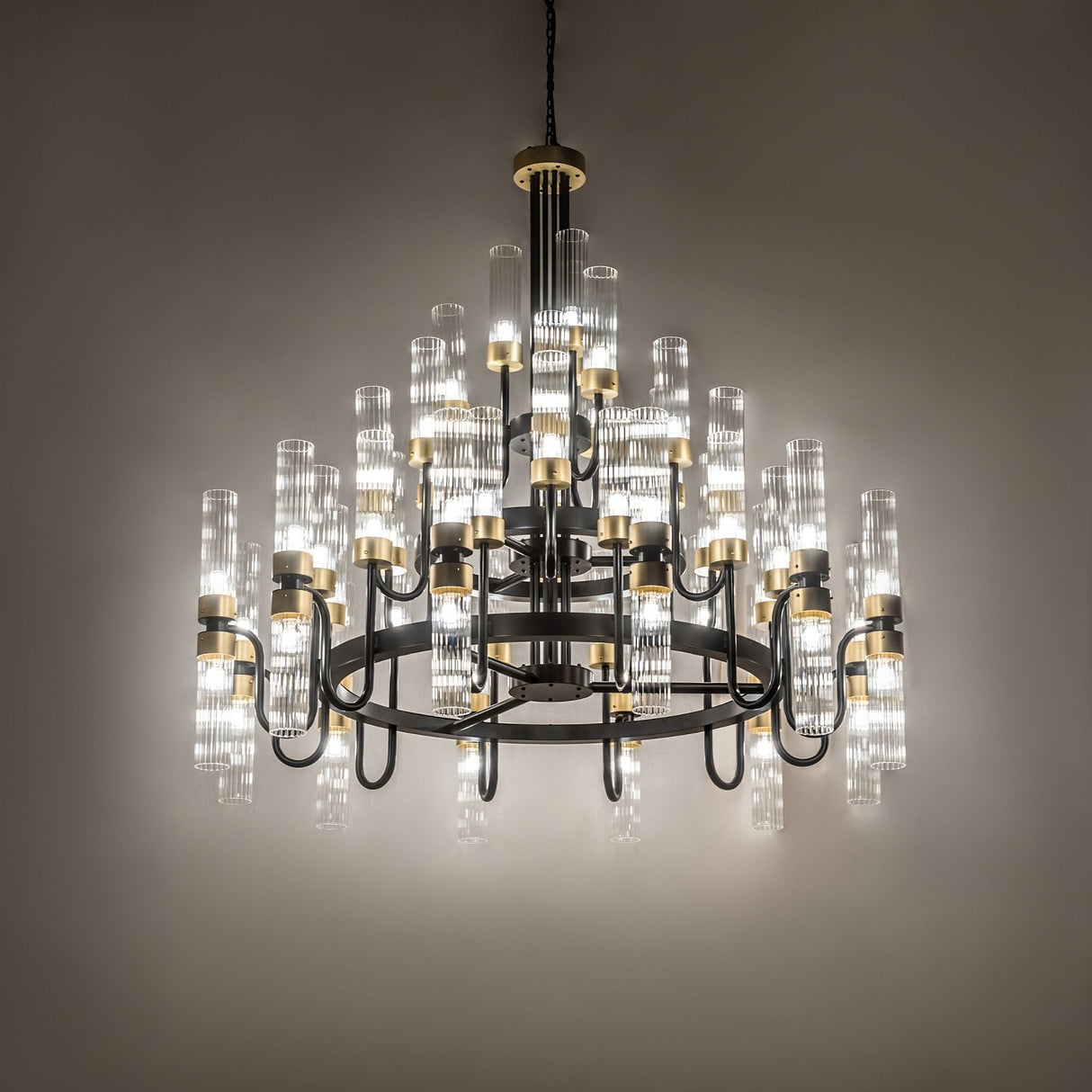 Kahler 54 light chandelier lit in ambient room setting with soft glow.